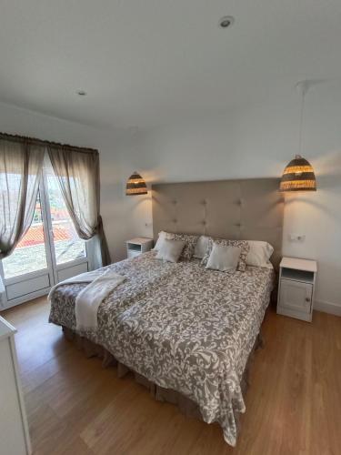 a bedroom with a large bed and two windows at Hotel Posada del Mar in Suances