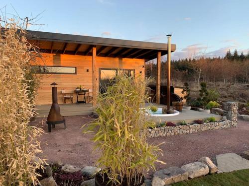 a small wooden cabin with a patio and a table at Peaceful Bothy Retreat in Nairn