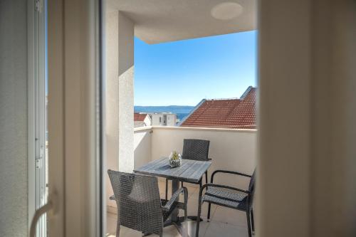 una mesa y sillas en un balcón con vistas en Apartments Mistral, en Bol