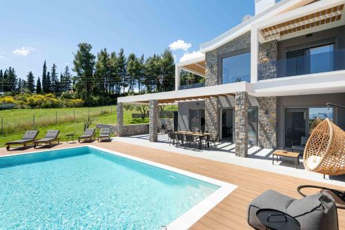 a villa with a swimming pool and a house at Koni Villas Agia Paraskevi by Halkidiki Villas in Agia Paraskevi