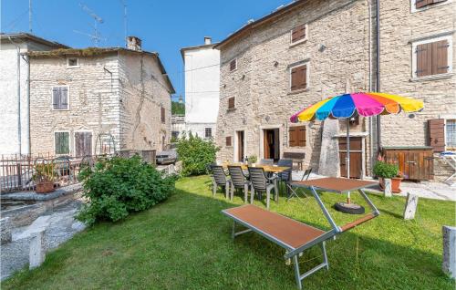 a patio with a table and a colorful umbrella at Casa Sant in SantʼAnna dʼAlfaedo