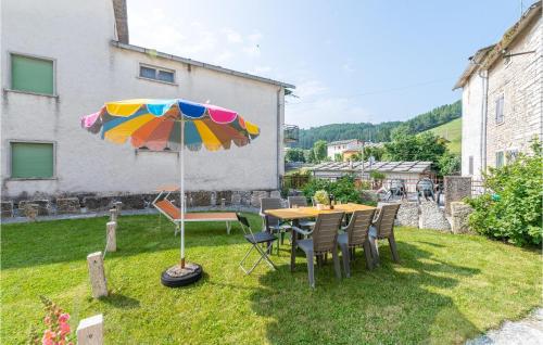 a table and chairs with an umbrella in a yard at Casa Sant in SantʼAnna dʼAlfaedo