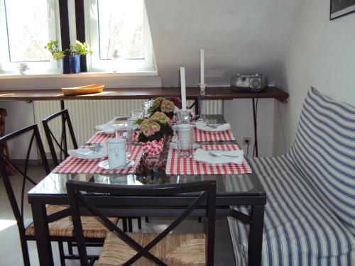 a dining room table with a red and white table cloth at Farm stay Hof auf der Wurp in Harrierwurp