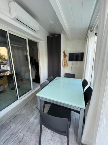 une salle à manger avec une table et des chaises bleues dans l'établissement Aux Ayguades, Pavillon tout confort proche plage, terrasse et WIFI, à Gruissan