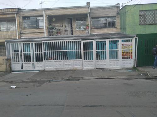 a white gate in front of a house at Habitación con baño privado cerca al aeropuerto in Bogotá