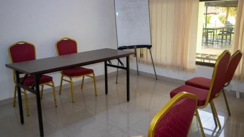 a classroom with a table and chairs and a chalkboard at Pekan Hotel in Accra