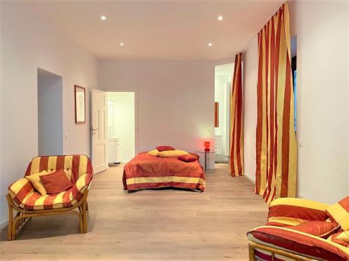ein Schlafzimmer mit einem Bett und zwei Stühlen darin in der Unterkunft Tanja's Comfort Apartment Brissago in Brissago