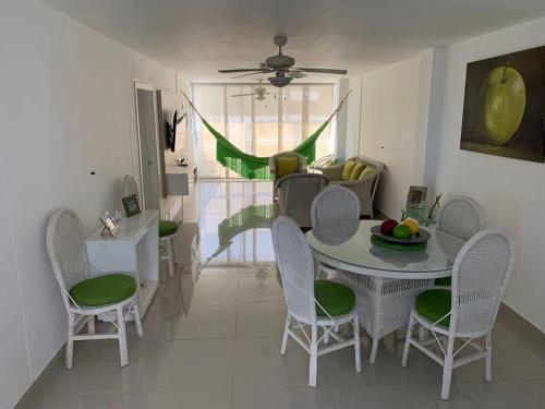 un comedor con mesa y sillas y una habitación con en Apartamento en el Rodadero, Confortable y amplio, con vista al mar, a 80mt de la playa, DELAMAR Apartmet, en Santa Marta