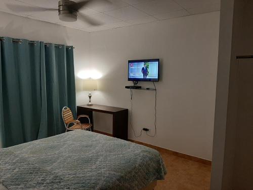 a bedroom with a bed and a flat screen tv at Bienvenidos a Guararé in Guararé