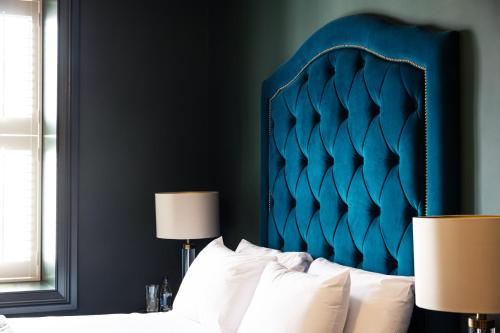 a bed with a blue headboard in a bedroom at Magmell Townhouse in Wicklow