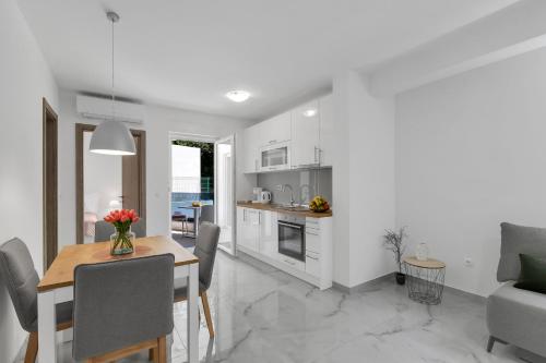 a kitchen and dining room with a table and chairs at Central Makarska - Apartments Šantrić in Makarska