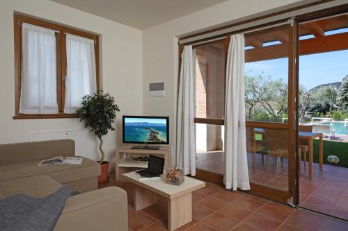 a living room filled with furniture and a tv at Appartamenti Corte Leonardo in Garda