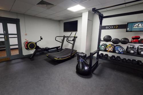 a gym with weights and equipment in a room at Village Hotel Liverpool in Prescot