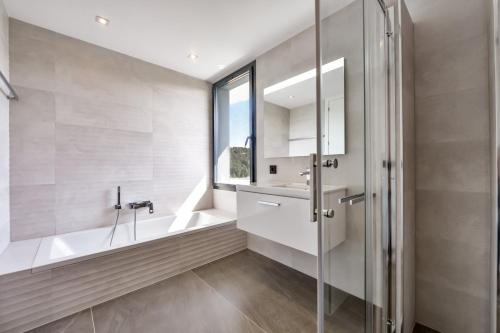 une salle de bain avec une baignoire, un lavabo et une fenêtre dans l'établissement Villa Sofia, à Jávea