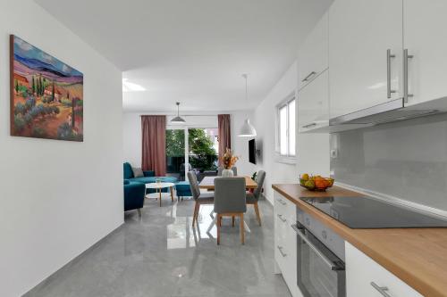a kitchen with white cabinets and a dining room at Central Makarska - Apartments Šantrić in Makarska
