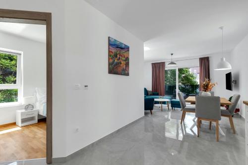 a dining room and living room with a table and chairs at Central Makarska - Apartments Šantrić in Makarska