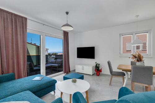 a living room with a blue couch and a table at Central Makarska - Apartments Šantrić in Makarska