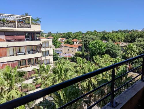 - un balcon offrant une vue sur un bâtiment avec des palmiers dans l'établissement Le Dory - Appartement Centre Ville avec Terrasse, Parking & Wifi, à Montpellier