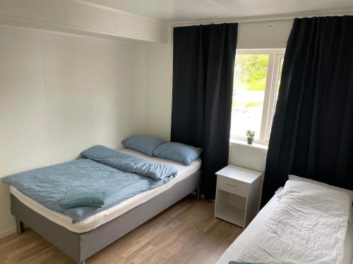 1 dormitorio con 2 camas y ventana en Veien til Senja, en Finnsnes