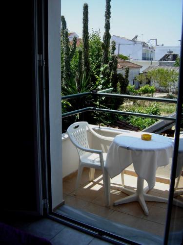 a white table and a chair on a balcony at Pansion Chrisa in Skiathos Town