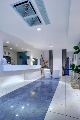 a lobby with a reception desk and a tile floor at Hotel Cristallo in Riccione