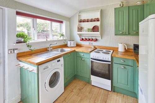 a kitchen with green cabinets and a washer and dryer at Host & Stay - Elliott Terrace in Wark