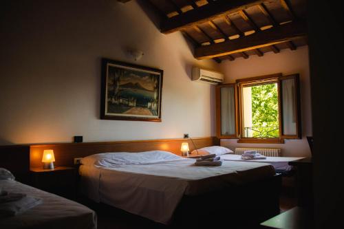 twee bedden in een slaapkamer met twee lampen erop bij SPIEDO IMPERIALE - Locanda e Ristorante in Cotignola