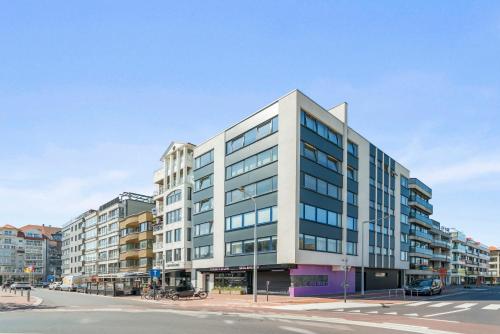 Un edificio alto y blanco en una calle de la ciudad. en Modern, mooi en stijlvol app vlakbij winkelstraat, en Knokke-Heist