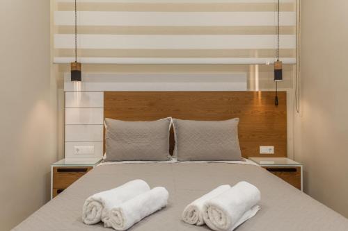 a bedroom with a bed with two towels at Athena Apartment in Heraklio Town