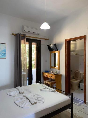 a bedroom with a bed and a bathroom with a sink at Archontika Apartments in Kerames