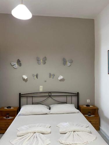 a bedroom with a bed with butterflies on the wall at Archontika Apartments in Kerames