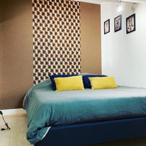 - une chambre dotée d'un grand lit avec des draps bleus et des oreillers jaunes dans l'établissement Le carrosse, la diligence, centre Saint Jean de Losne tarif 2pers 1 chambre, tarif 4 pers 2 chambres, à Saint-Jean-de-Losne