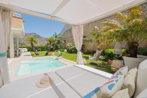 un patio con piscina, mesa y sillas en Villa Mastrissa Taormina, en Taormina