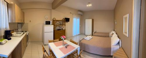 eine Küche und ein Wohnzimmer mit einem Tisch im Zimmer in der Unterkunft Tsatsoni - Anastasiou Studios in Velika