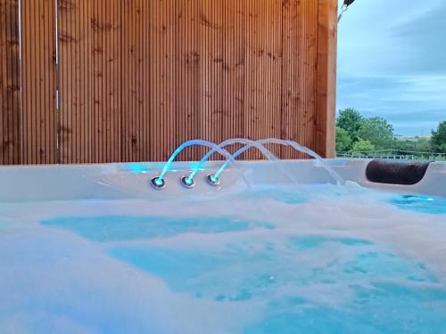 - un jacuzzi avec eau bleue dans un bâtiment dans l'établissement Domaine bulle étoilée, à Rouilly-Sacey