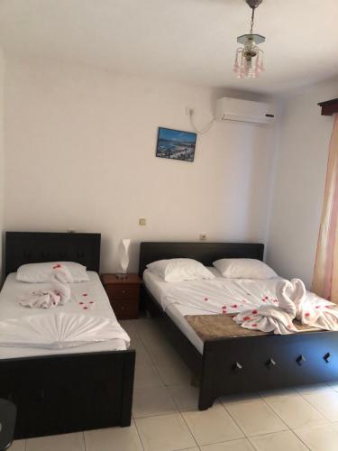 two beds in a room with towels on them at Vila Xhafa in Ksamil