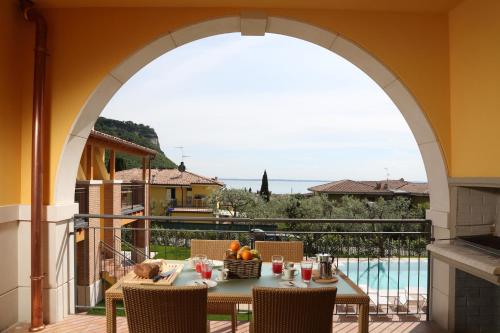 a dining room with a balcony overlooking a river at Appartamenti Corte Leonardo in Garda