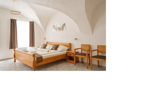 een slaapkamer met een bed, een tafel en een stoel bij Penzion Kardinal in Mikulov