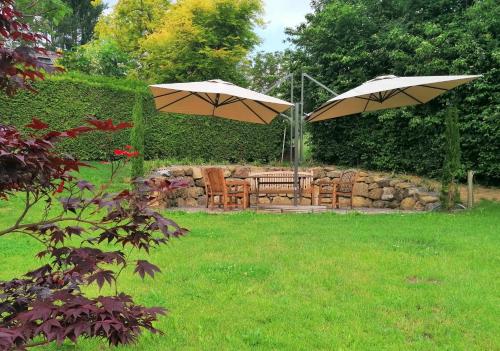 two umbrellas and a table and chairs in a yard at Landhaus Stenitzer in Bairisch Kölldorf