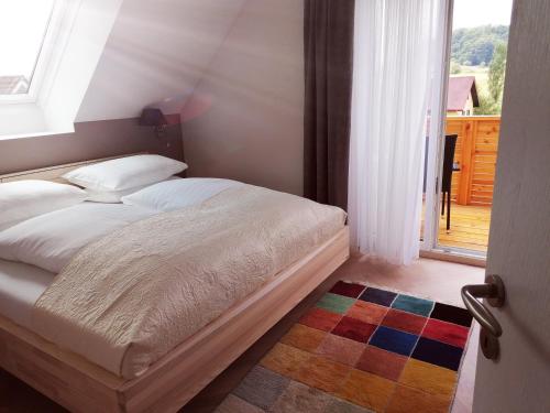 1 dormitorio con cama, ventana y alfombra en Landhaus Stenitzer 