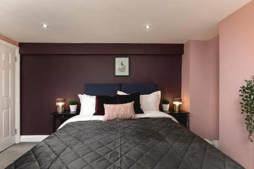 a bedroom with a large bed with purple walls at Brighton Beach 2BR AP with Patio in Brighton & Hove