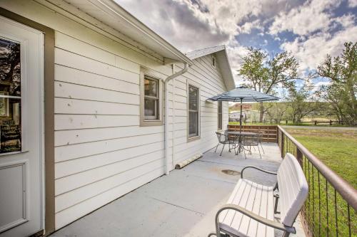 a porch with two benches and an umbrella at Lovely Thermopolis Home Less Than 3 Mi to Hot Springs in Thermopolis