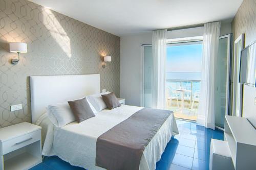 a bedroom with a bed and a large window at Hotel Gorini in Bellaria-Igea Marina