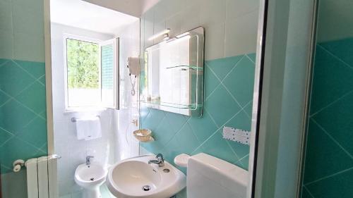 a bathroom with a sink and a toilet and a window at Summer Vibes B&B in Forio d'Ischia