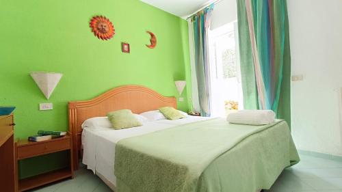 a green bedroom with two beds and a window at Summer Vibes B&B in Forio d'Ischia