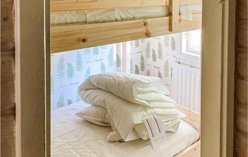 a bunk bed with pillows in a room with a window at Awesome Home In Brcke With Lake View in Baksjöbodarna