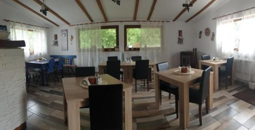 un comedor con mesas, sillas y ventanas en Casa langa rau, en Bran