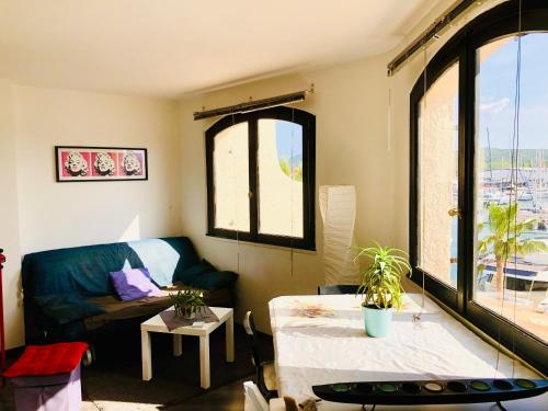 ein Wohnzimmer mit einem Sofa und einem Tisch in der Unterkunft Petit Cocon magnifique vue sur Marina dans le golfe de Saint Tropez in Cogolin