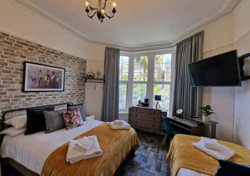 a hotel room with two beds and a tv at Lansdowne Simply Stay in Redruth
