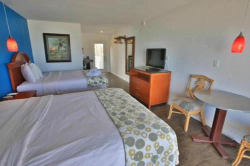 a hotel room with a large bed and a table at Daytona Dream Inn By AmeriVu in Daytona Beach